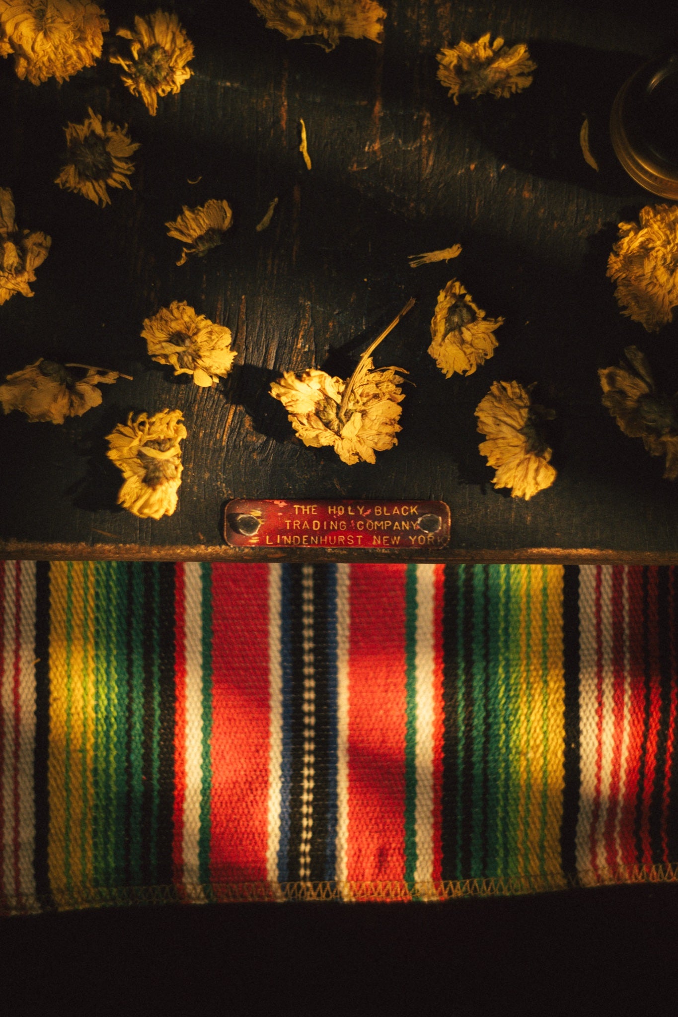 La Ofrenda by The Holy Black, brass plaque marigolds woven mat