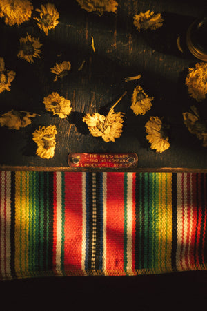 La Ofrenda by The Holy Black, brass plaque marigolds woven mat